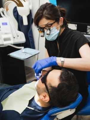 Dental team performing endodontic treatment at Promenade Village Dental